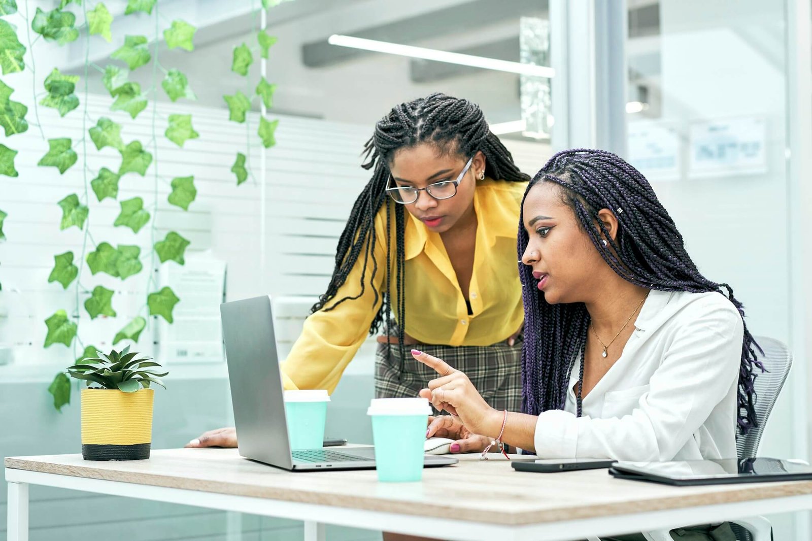 two-young-black-women-reviewing-analytical-data-on-various-electronic-devices-.jpg